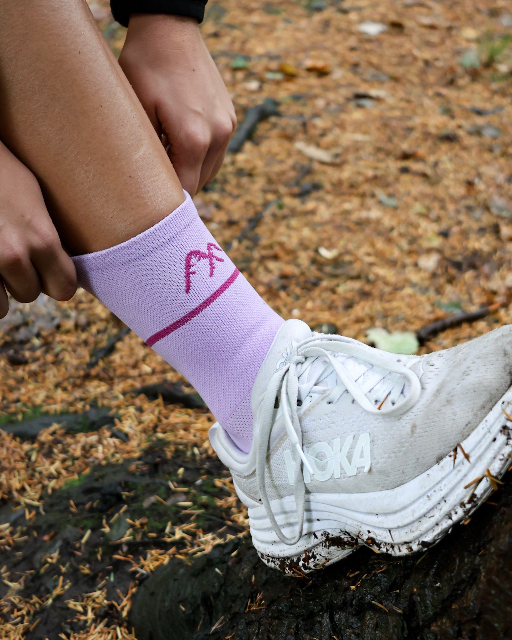 purple running socks being adjusted in woodland